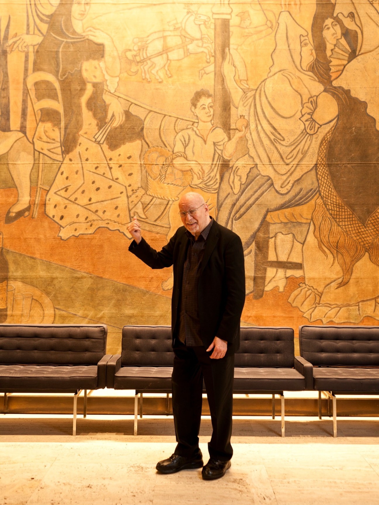 George Lois stands before a large stage curtain painted by Picasso at The Four Seasons restaurant.