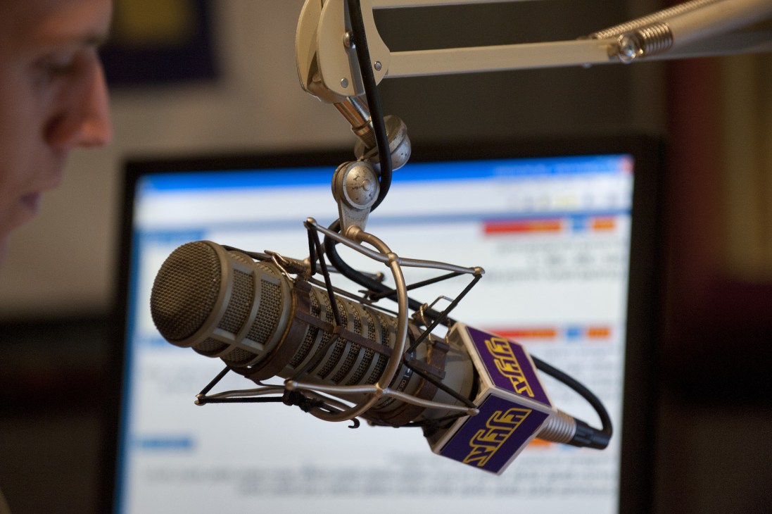 Professional studio microphone with shock mount suspended in a radio studio.