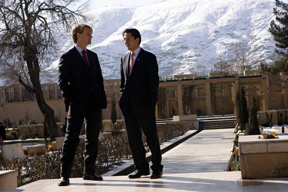 Said Jawad and a US diplomat converse in the Serena hotel gardens with snow-capped mountains in the background.