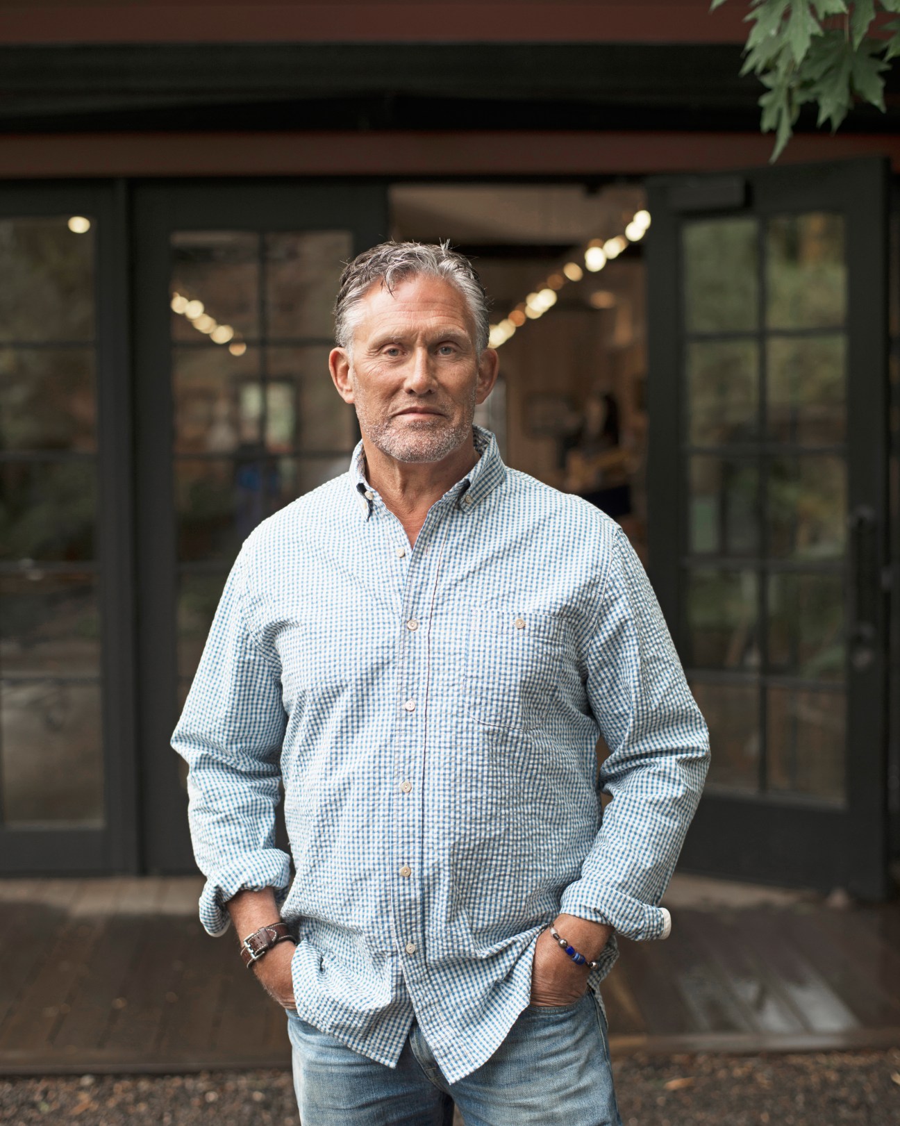 Stephen Gordon, owner of Guideboat Co, standing outside a storefront in a light blue checkered shirt.