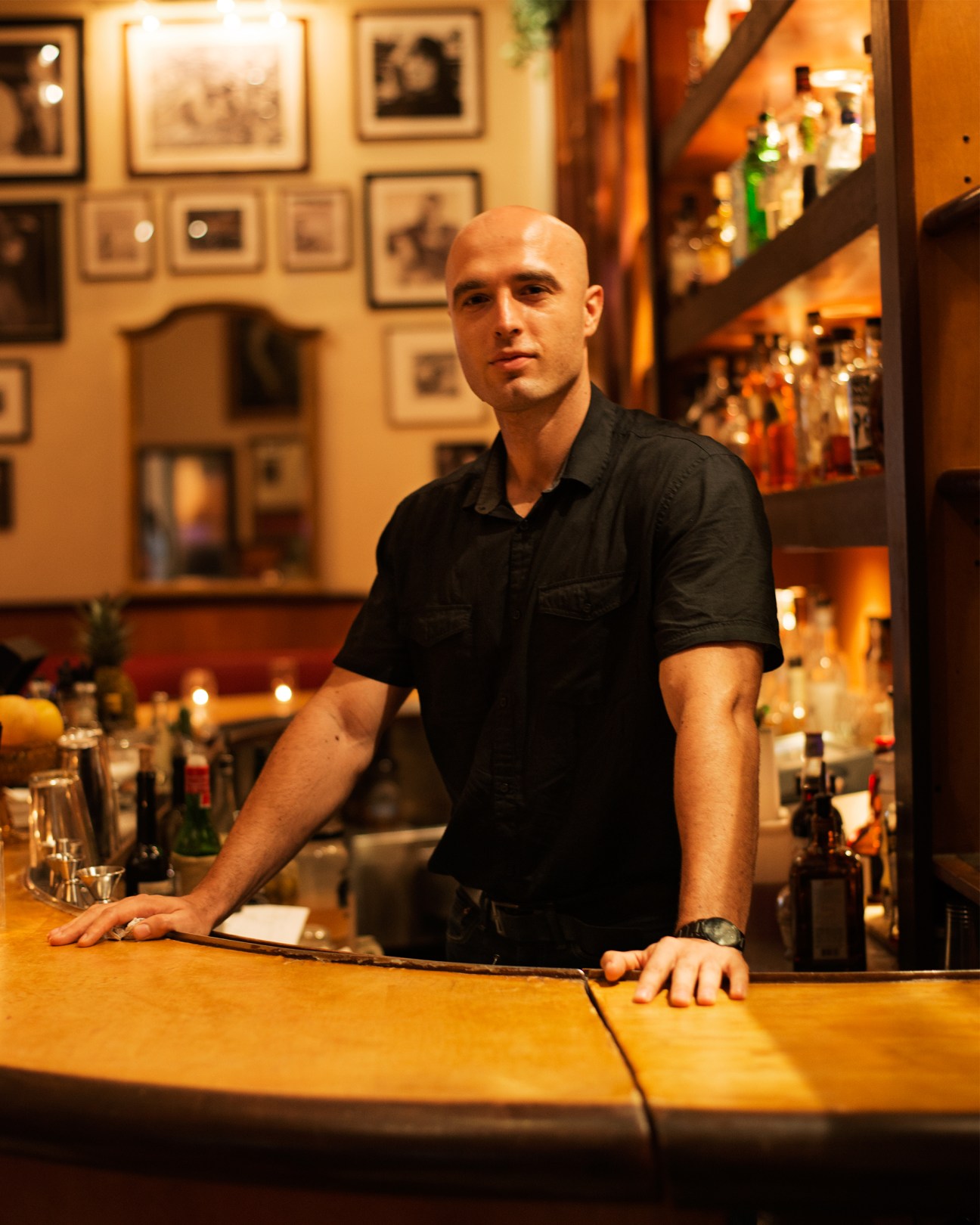 Nash Pacariz, barman at Martini Bar in The Raleigh hotel, standing behind the bar in warm lighting.