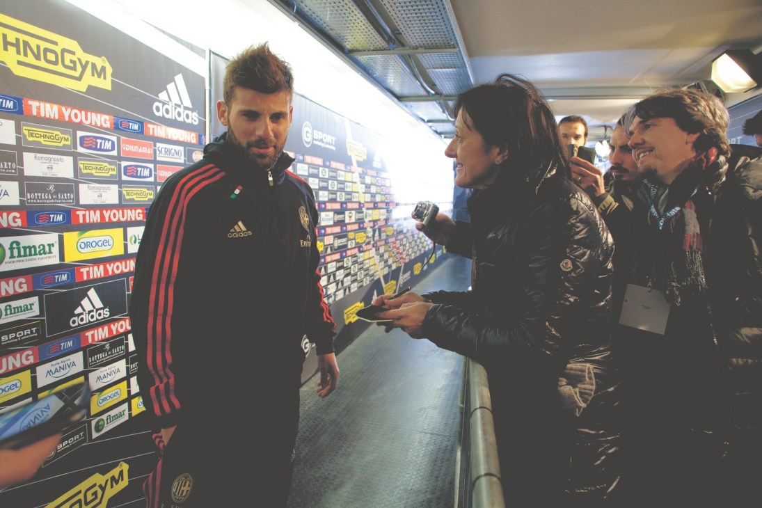 Alessandra Bocci interviews AC Milan midfielder Antonio Nocerino at a stadium press area with sponsor logos in the background.