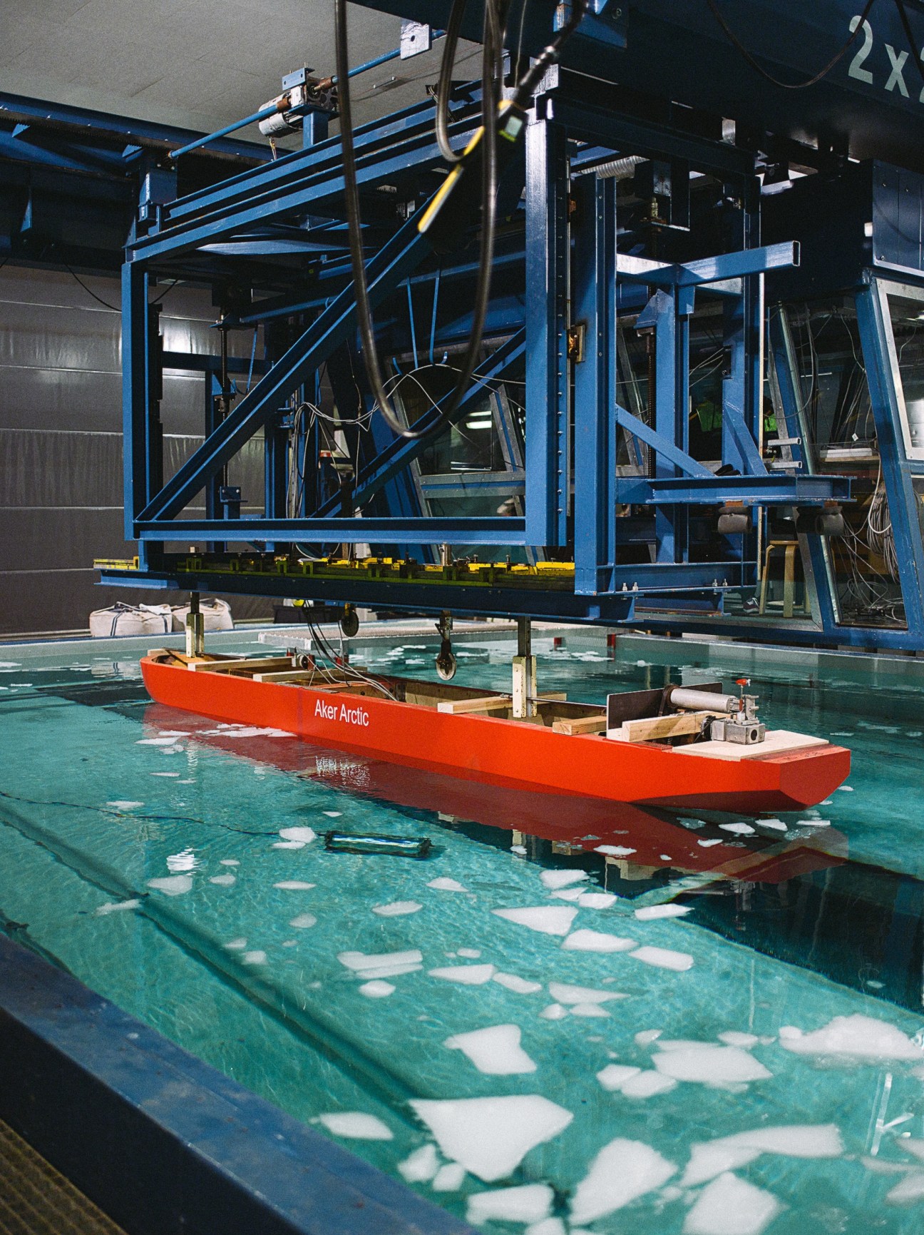 Red Aker Arctic scale model ship testing in ice basin with simulated ice conditions.