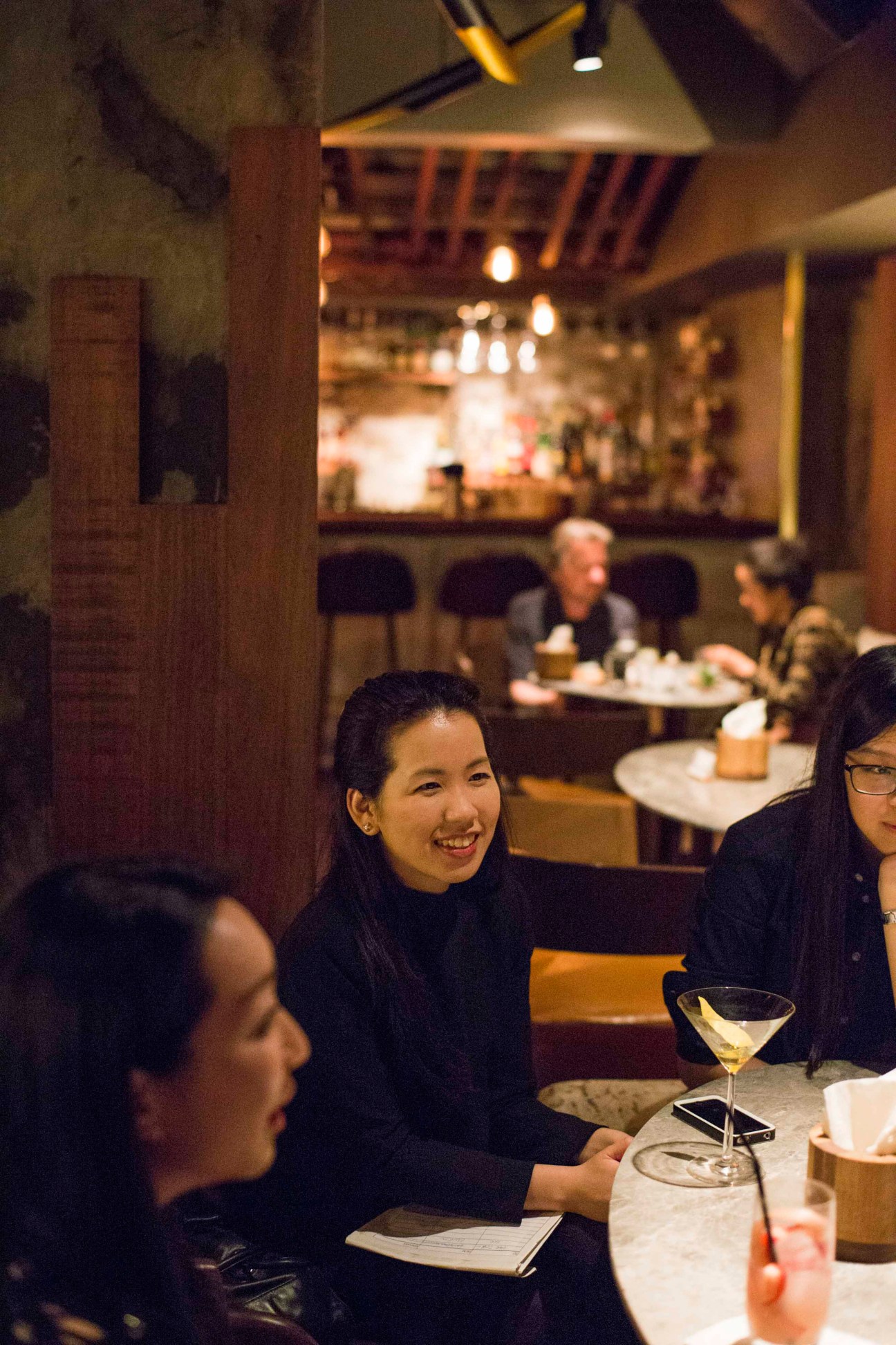 Women enjoying cocktails at The Woods bar in Hong Kong.