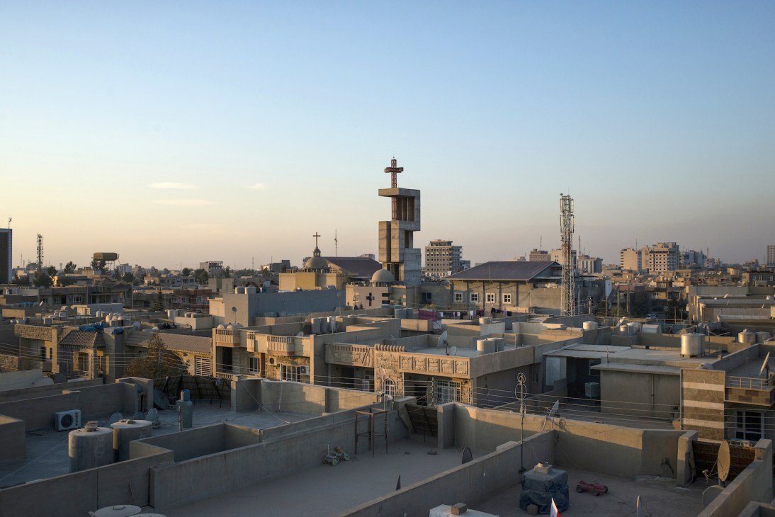 Rooftop view of Erbil's Ankawa neighbourhood with multiple churches featuring crosses and modern buildings under clear sky.