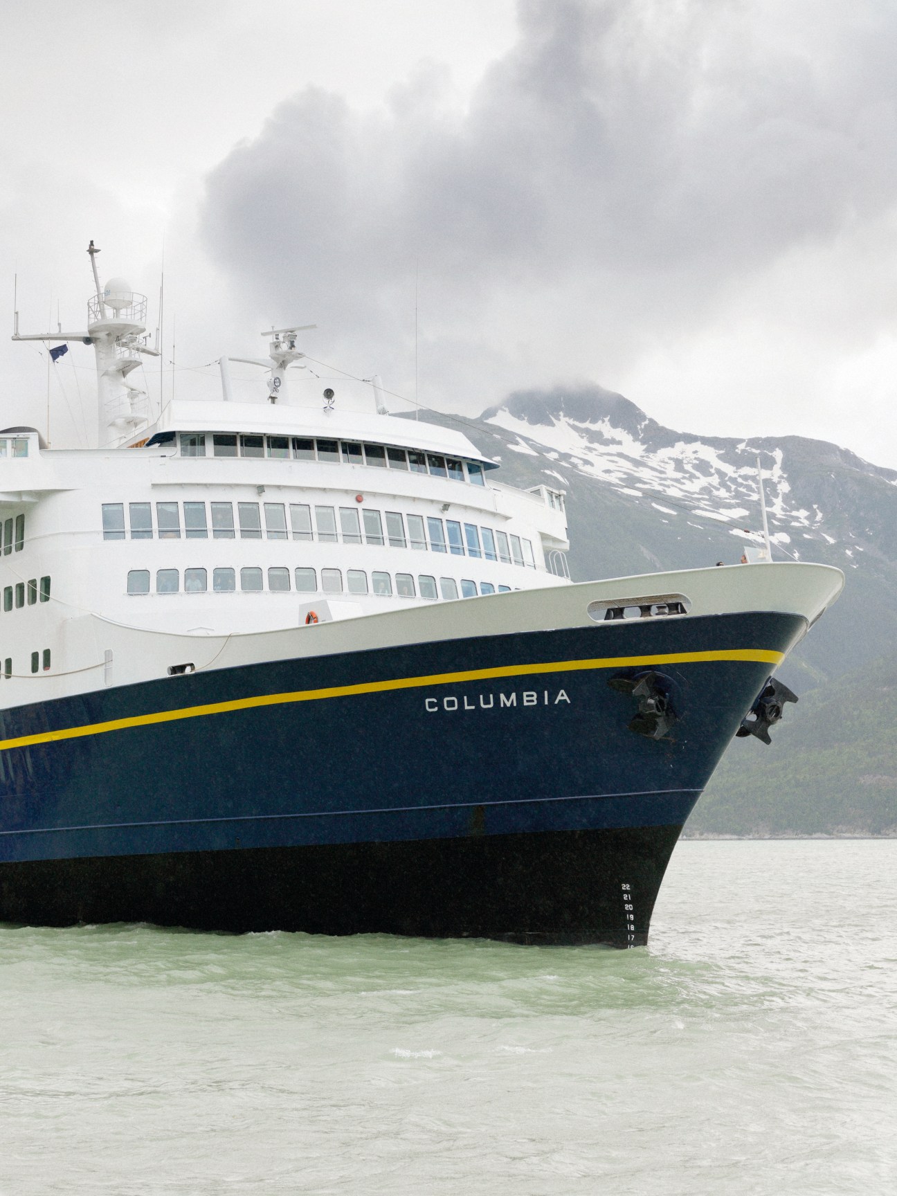 The M/V Columbia ferry arriving in Skagway with snow-capped mountains in the background.