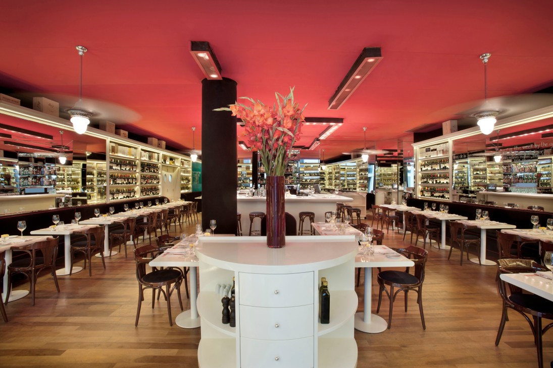 Aldo's Vinoteca & Restoran interior with red ceiling, wine displays, and dining tables.
