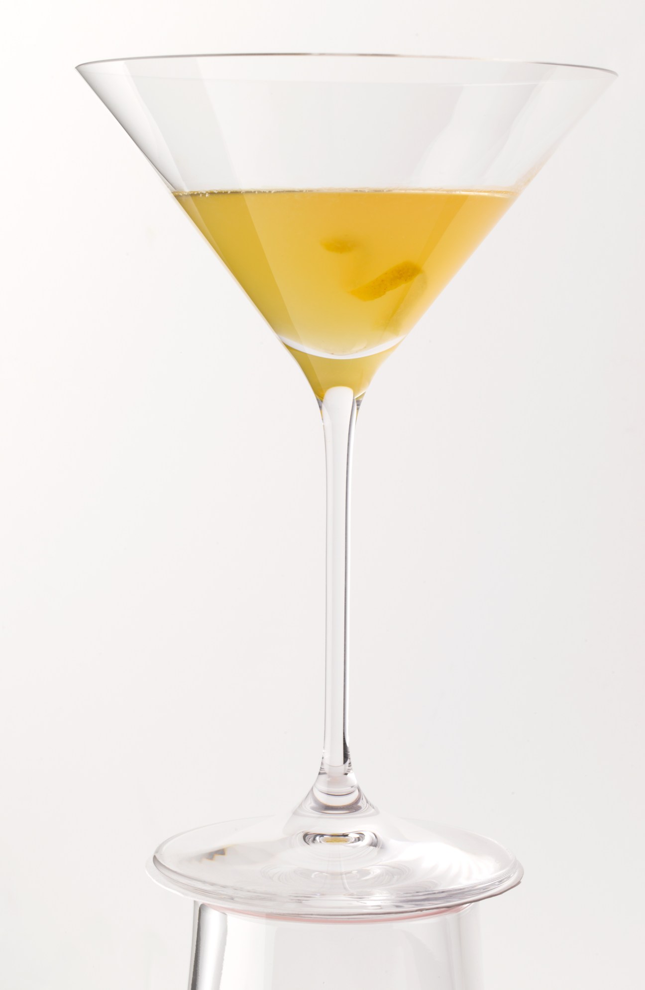Sidecar cocktail in a martini glass with pale yellow liquid and olive garnish.
