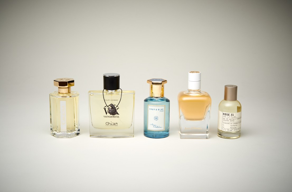 Five perfume bottles displayed in a row against a neutral background, showcasing fragrances made in Grasse.