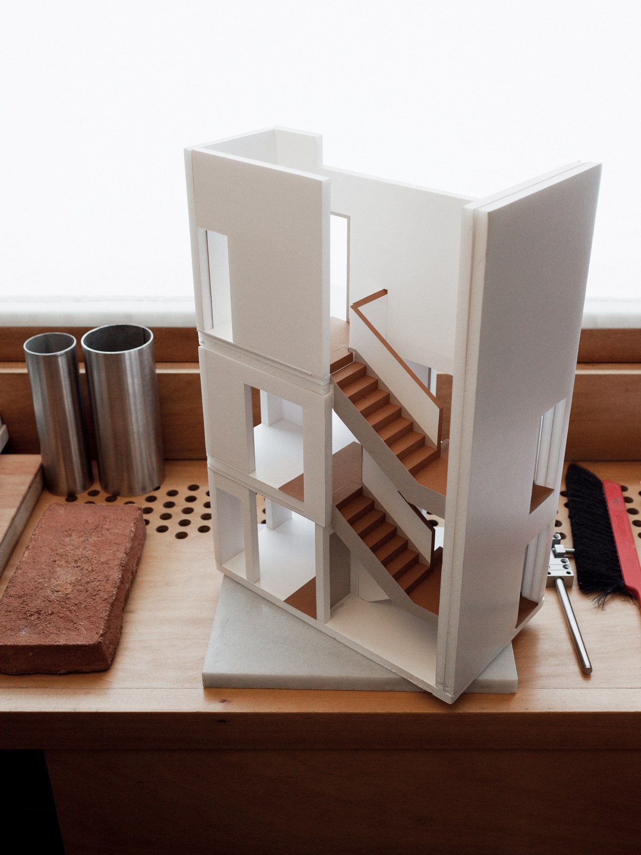 Architectural white model with wooden staircase on display desk at Álvaro Siza's office.
