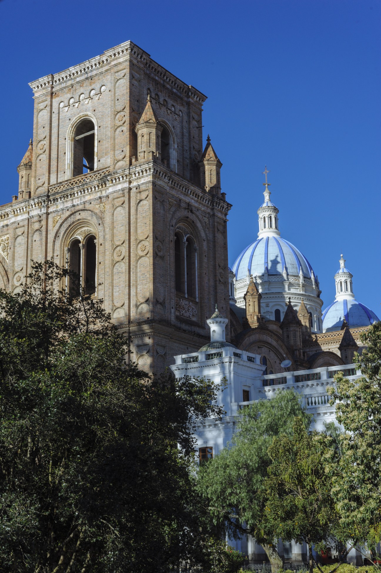 Cuenca Cathedral with blue dome and ornate stone bell tower against clear sky.