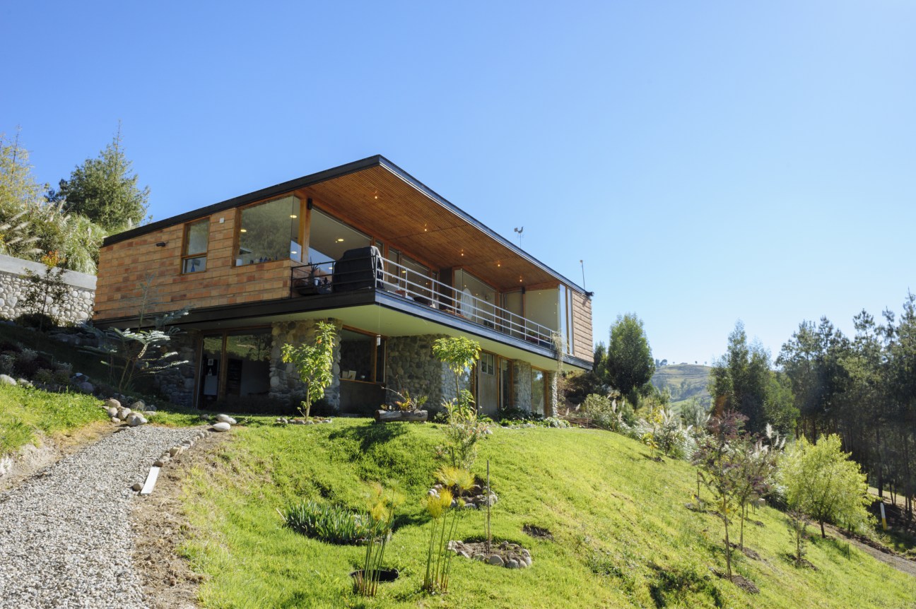 Modern wooden house with metal railings on hillside near Cuenca, Ecuador