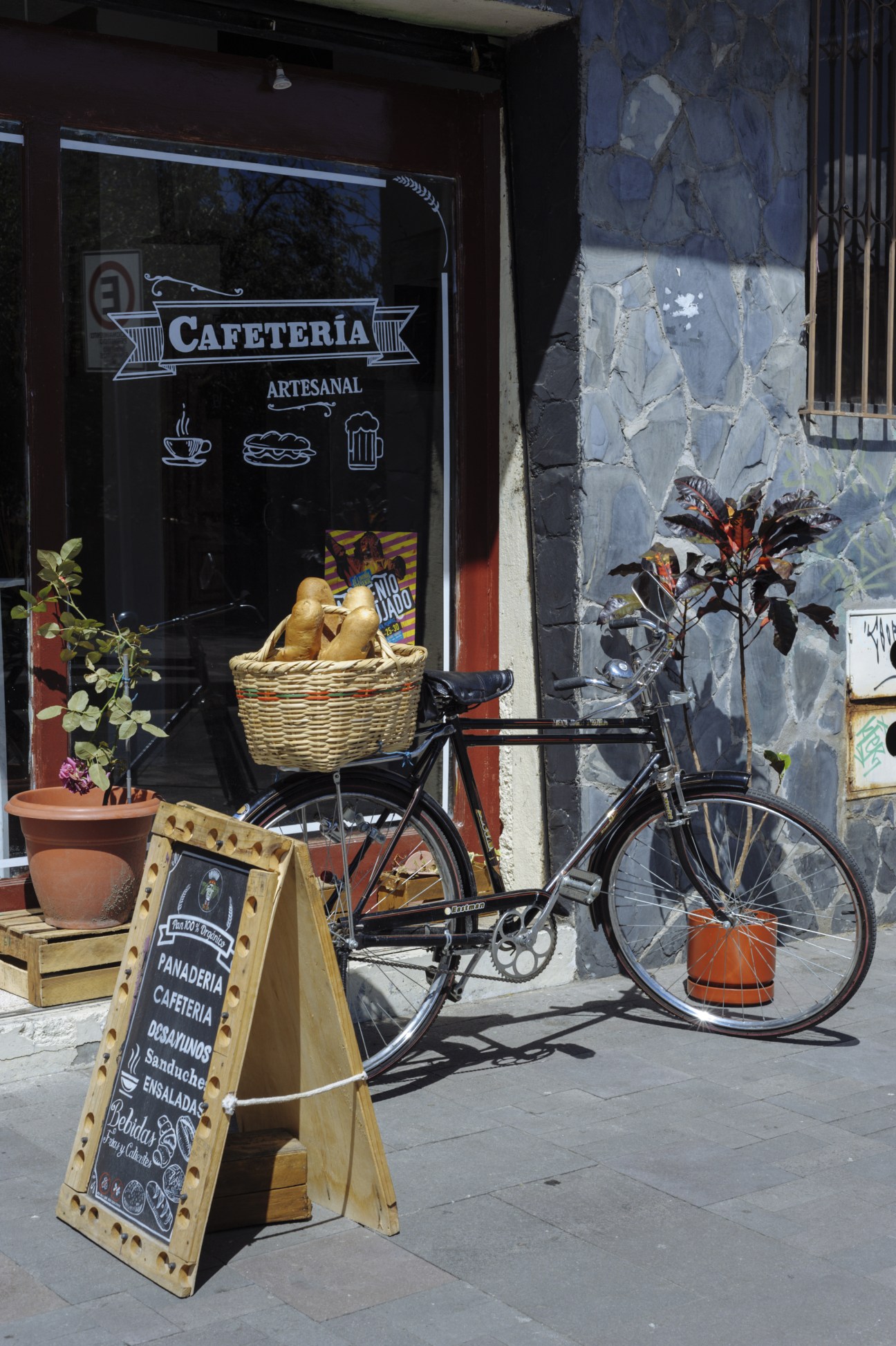 Café storefront on Calle Larga with bicycle loaded with bread basket and wooden menu board.