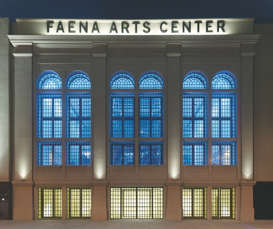 Faena Arts Center in Buenos Aires illuminated at night with blue arched windows.