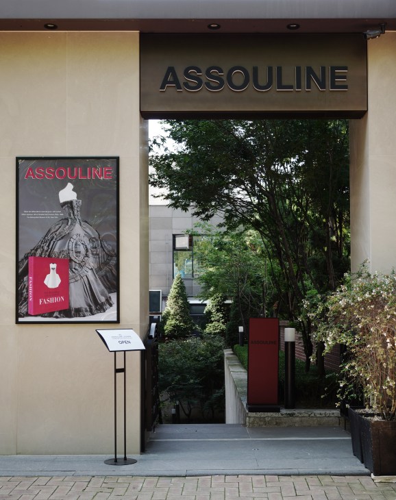 The entrance to Assouline bookstore in Seoul's Gangnam district, featuring signage and a fashion publication poster.