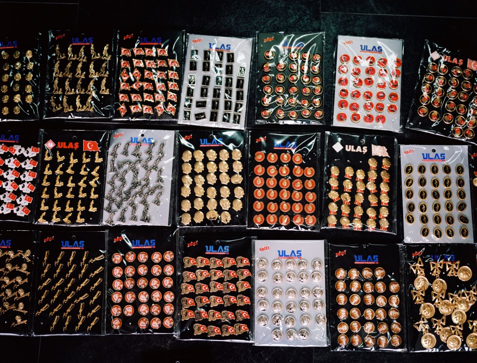 Multiple packaged sheets of Ataturk lapel pins and brooches in gold and red colors displayed at the Ulas factory.