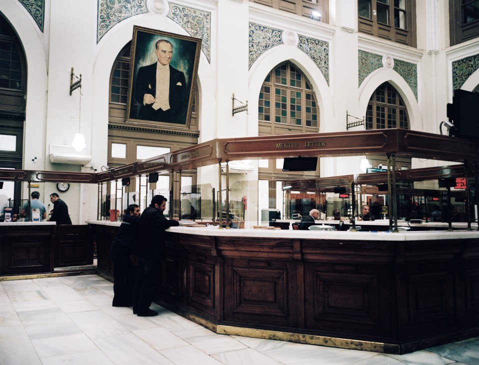 Post office in Sirkeci with a large portrait of Ataturk in a smoking jacket hanging above the counter.