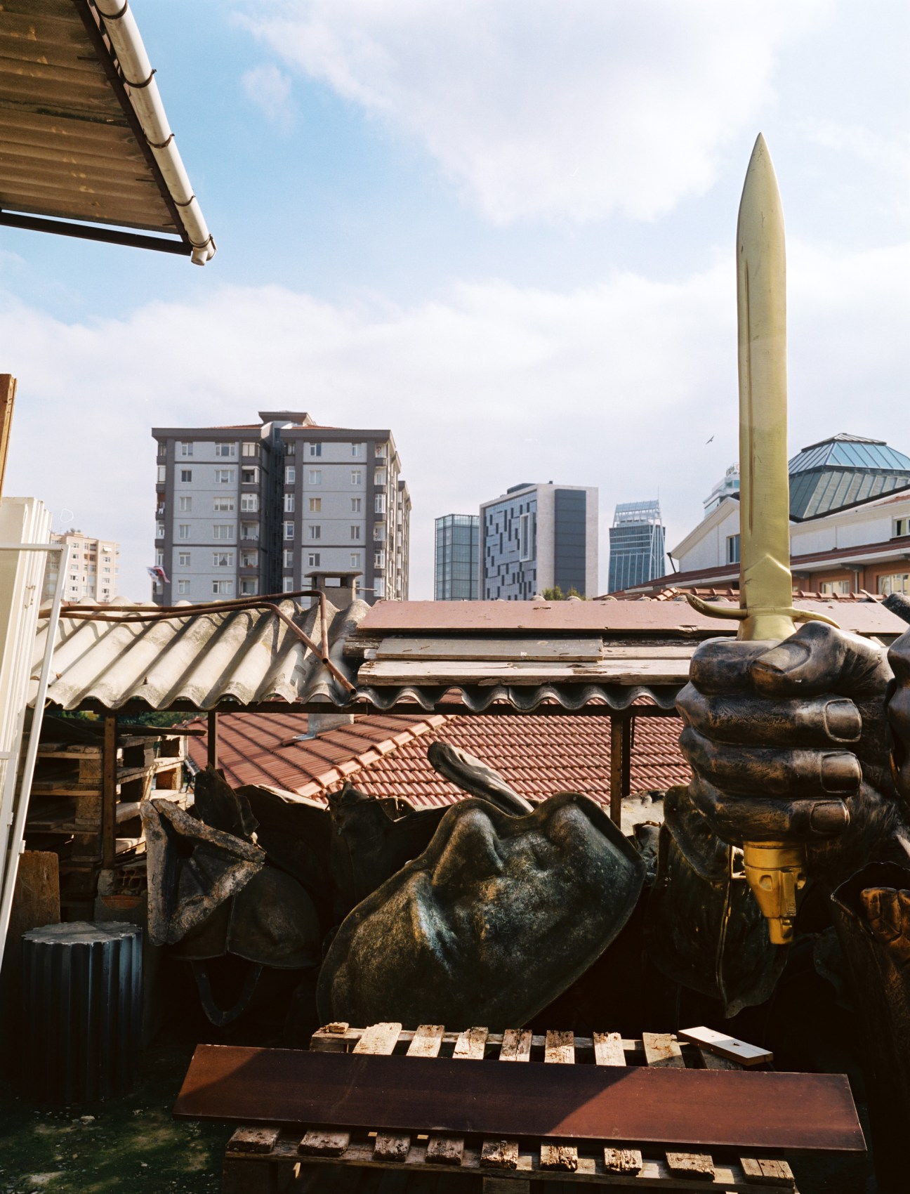 Large bronze mould of Ataturk's head in a sculptor's yard with Istanbul cityscape in background.