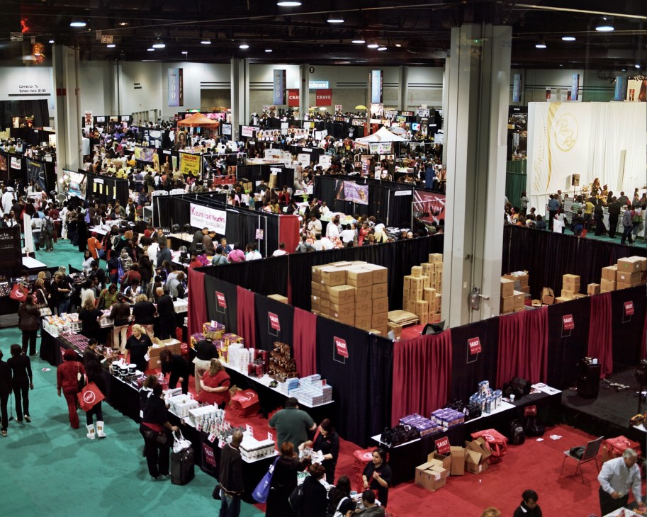 Aerial view of the crowded Bronner Brothers hair show exhibition hall with vendor booths and attendees.