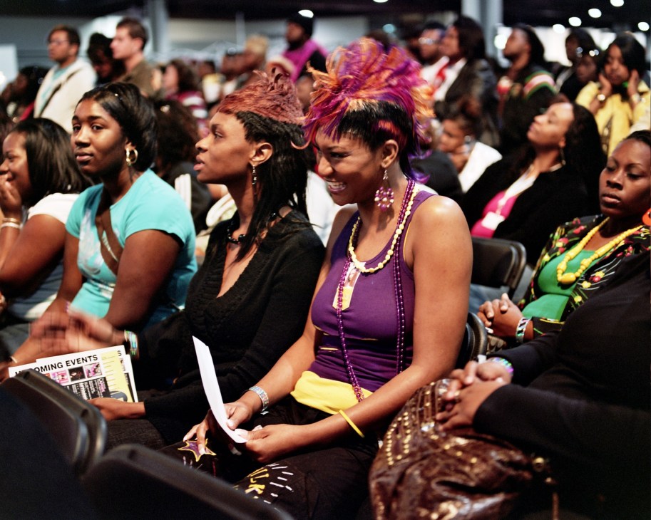 Diverse audience members seated at the Milky Way stage, featuring attendees with colorful hairstyles and vibrant clothing.