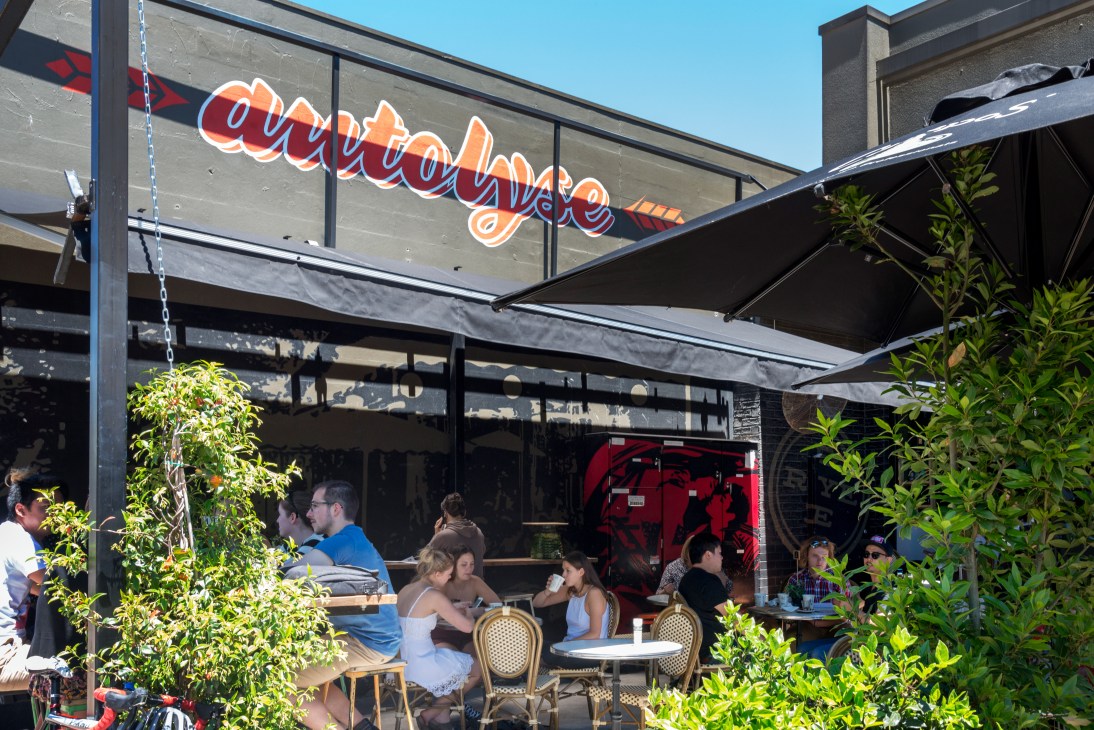 Customers dining at outdoor tables under a black awning at Autolyse Bakery and Café in Braddon, Canberra.