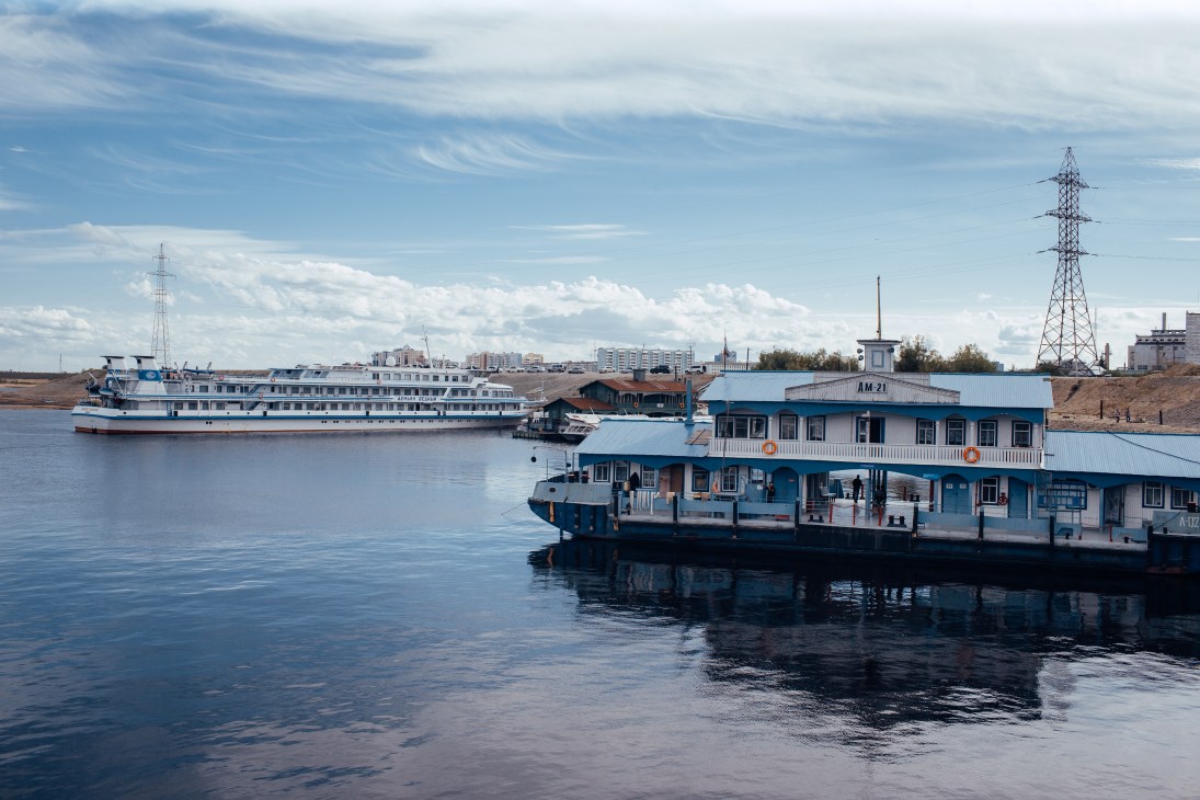 River station and passenger ferry on the Lena River in Yakutsk with city skyline in background.