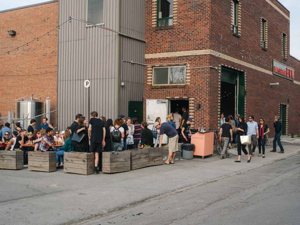 People gather outside Alexandraplatz bar in a converted brick bottling plant with wooden seating.