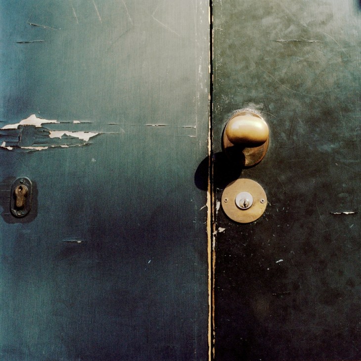 Brass 'Potato' handle on weathered green door of Casa Pirelli residence