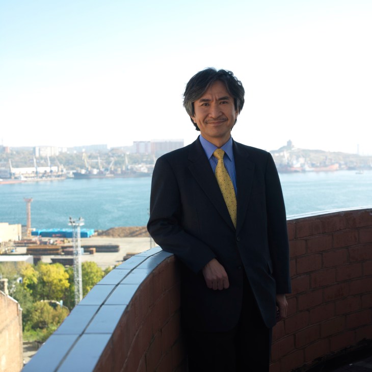Jun Yamada, Japanese consul general, stands on a rooftop overlooking Vladivostok's harbor and cityscape.