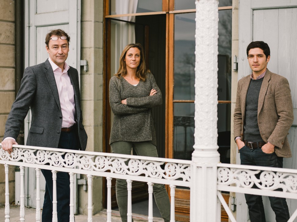 Three staff members from the Centre for Humanitarian Dialogue stand on a balcony in Geneva.