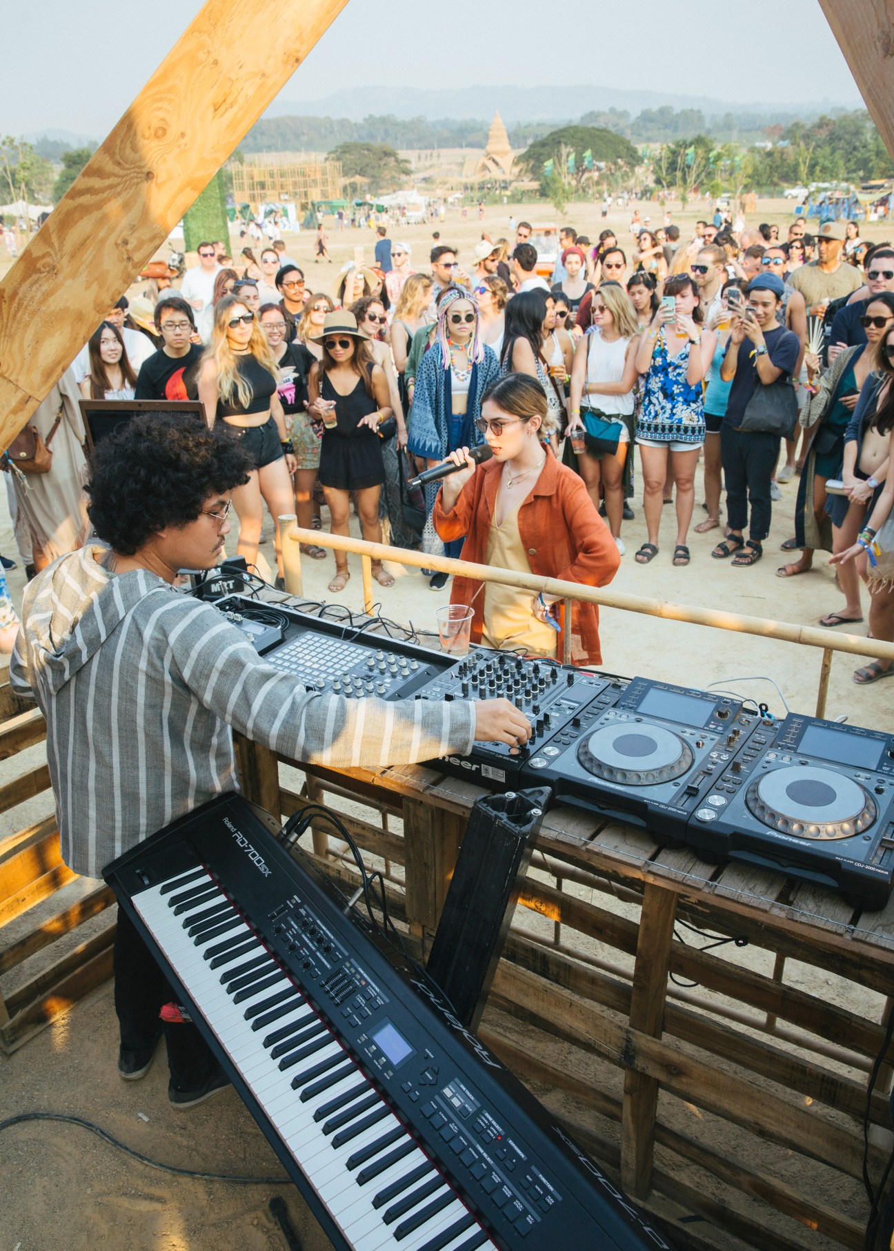DJ Lustbass performs at the Solar Stage at Wonderfruit festival with a large crowd gathered in the Thai countryside.