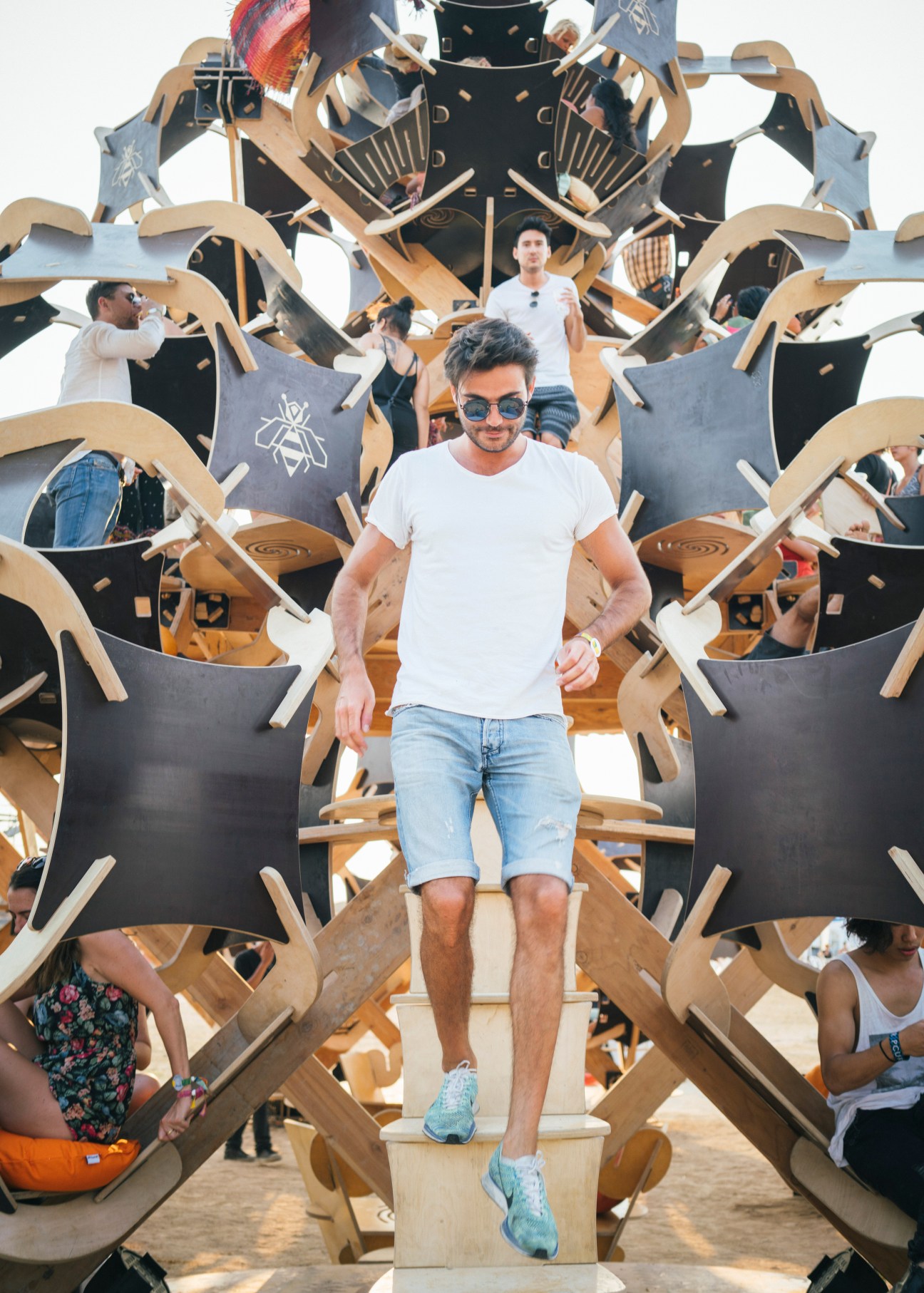 Festival attendee walking through wooden Solar Stage structure at Wonderfruit festival in Thailand.