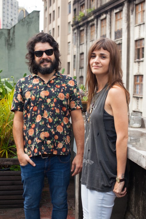 O Farol's founders Elohim Barros and Renata Mein stand together on a rooftop in São Paulo.