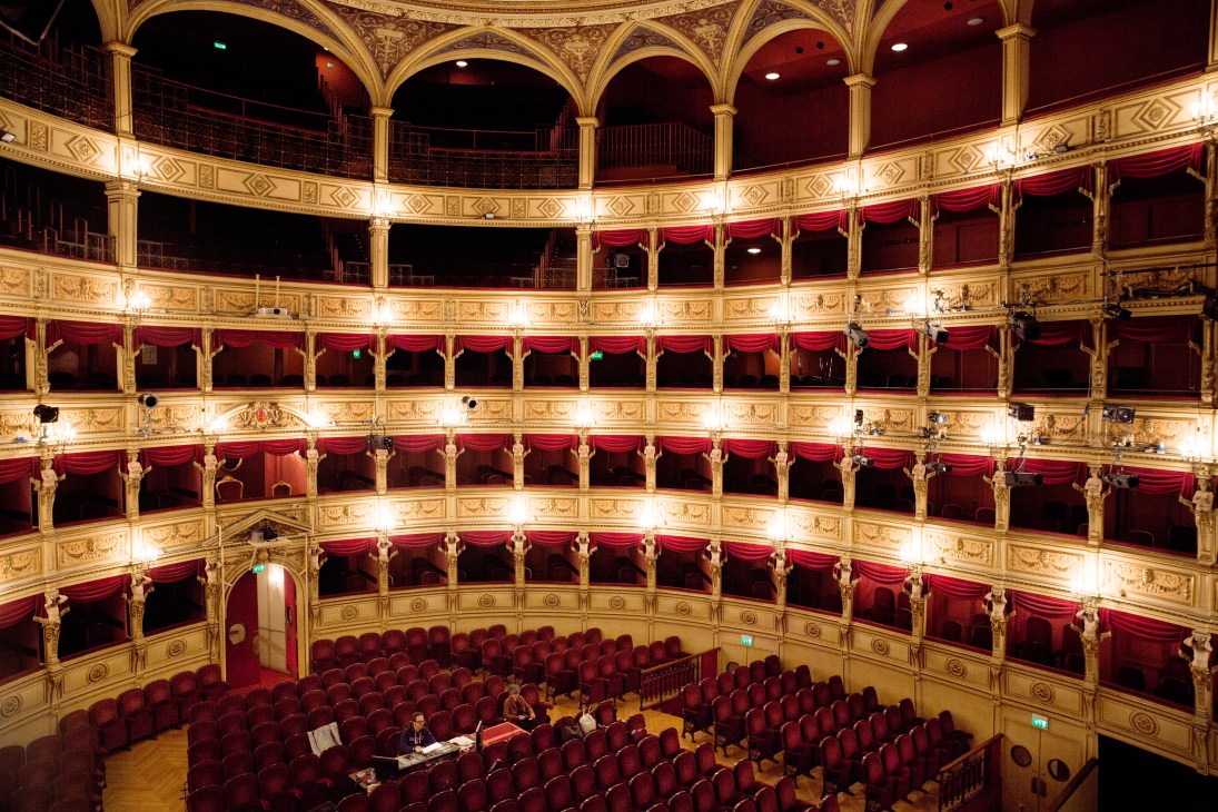 Interior of Teatro Lirico Giuseppe Verdi opera house with ornate gold detailing, red velvet seating and balconies.