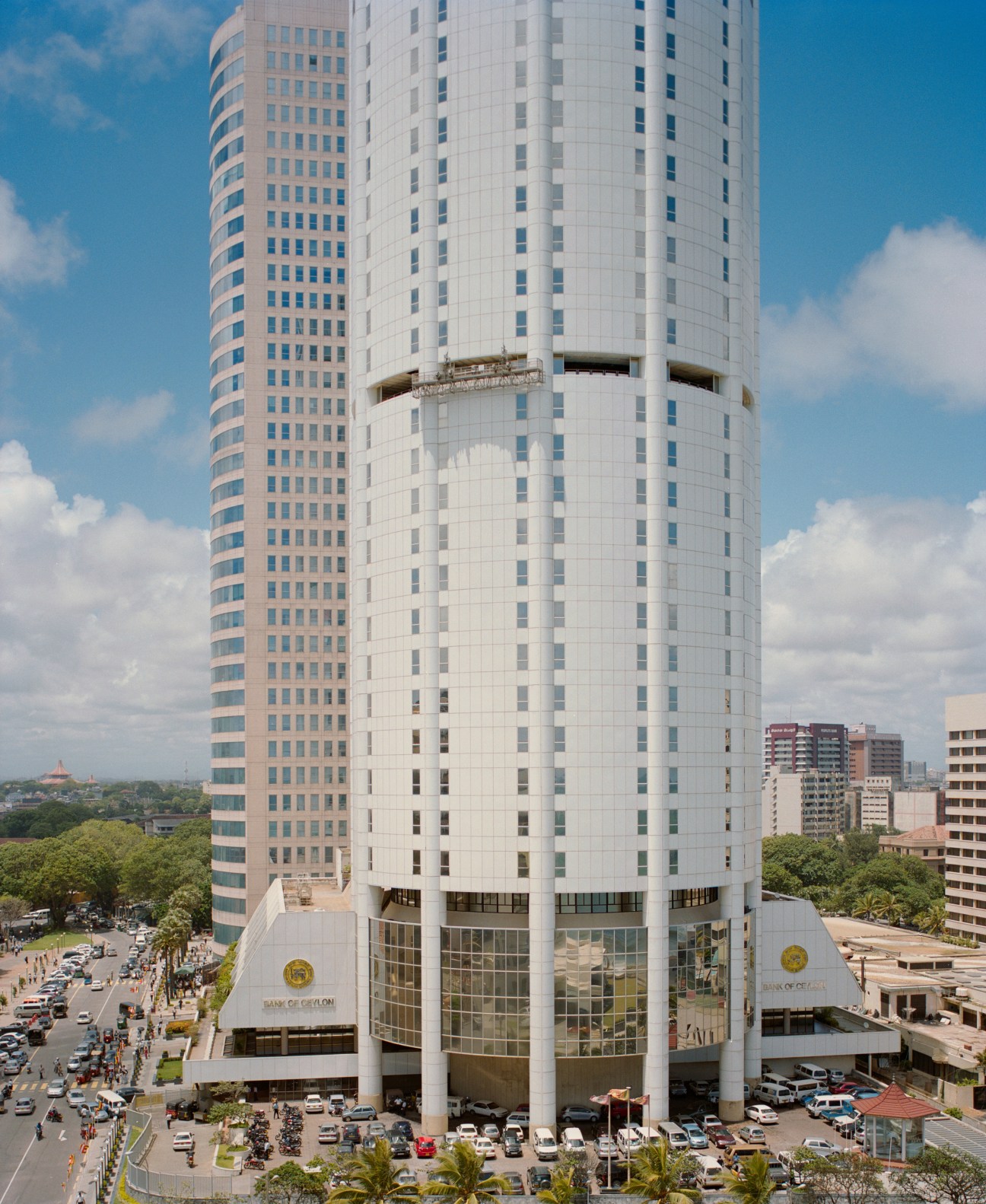 Bank of Ceylon and World Trade Centre twin towers in Colombo with cylindrical white facade and blue-tinted windows against cloudy sky.