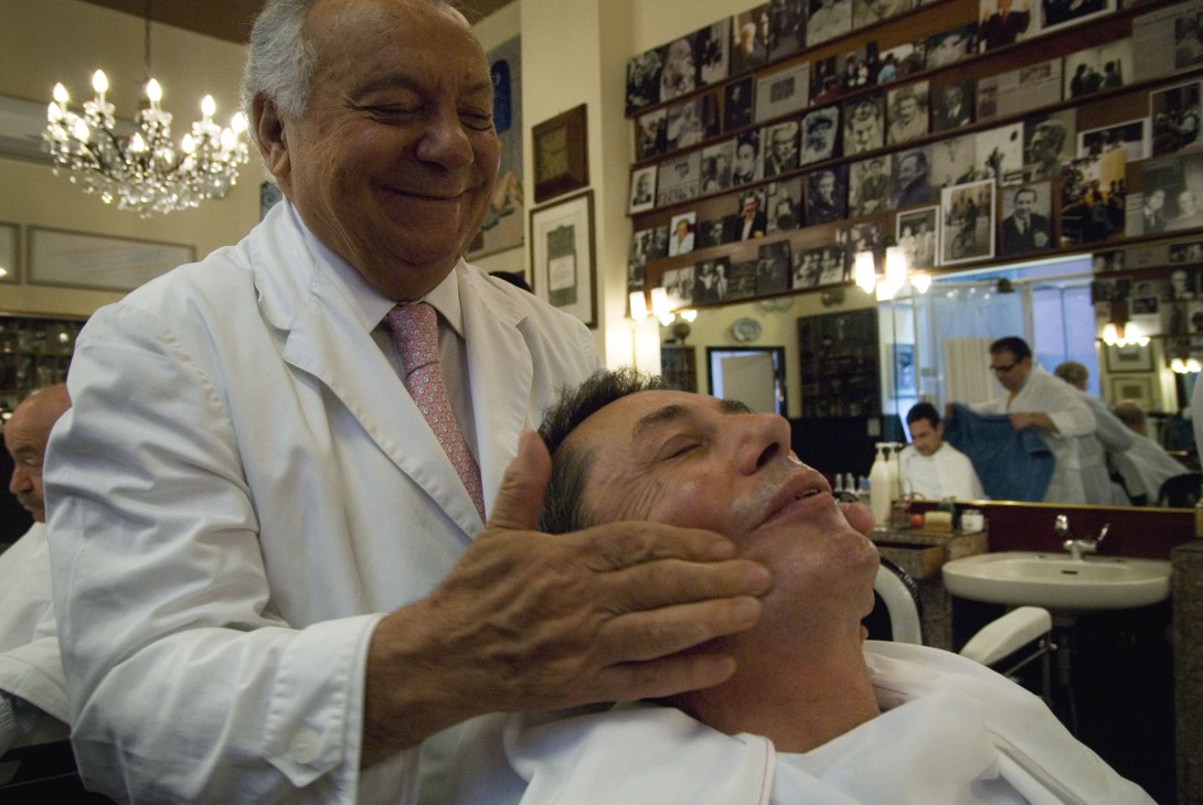 Barber Franco Bompieri performing a facial massage on a client in his Milan barbershop.
