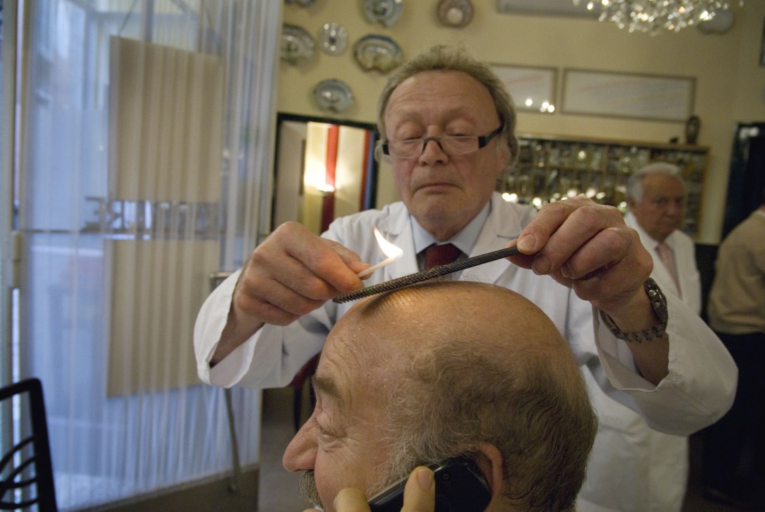 Milan barber Franco Bompieri combs a customer's hair in his traditional barbershop.