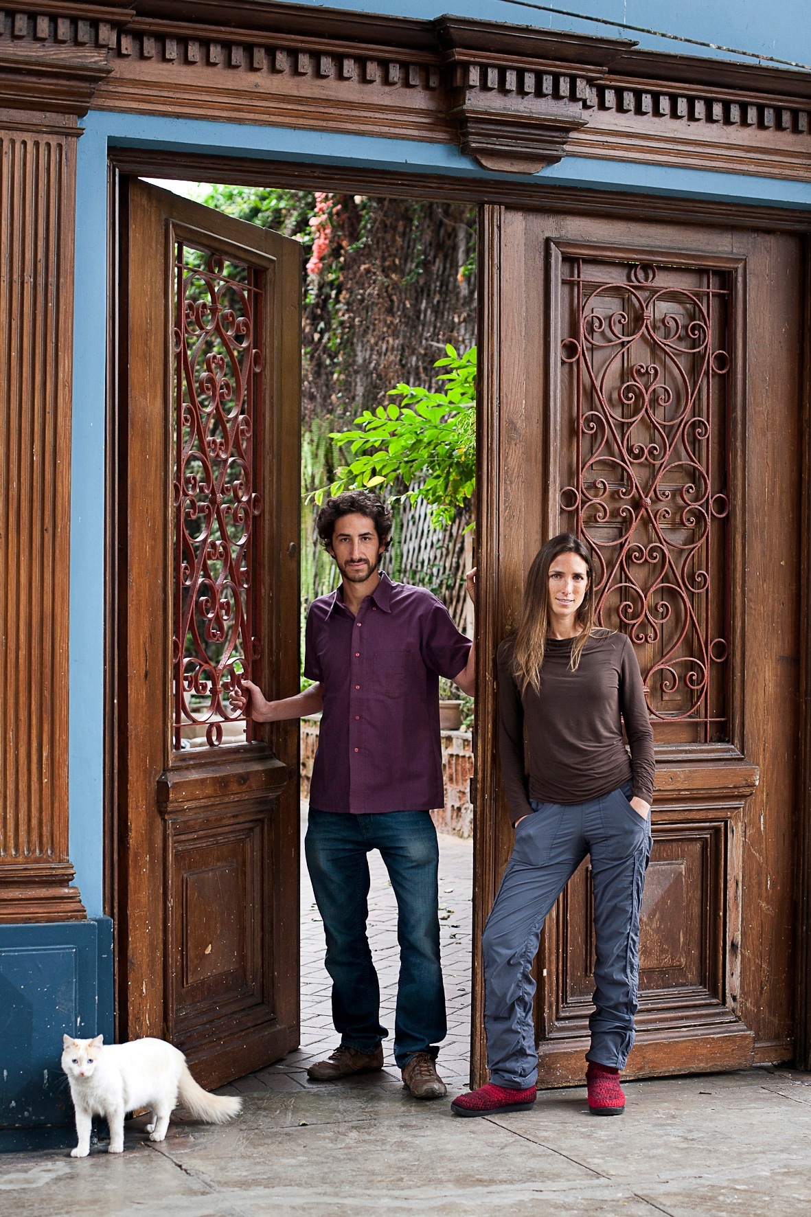 Residents Mariana Tschudi and Juan Manuel Benavides stand in the doorway of a restored colonial house with ornate wooden doors in Barranco, Lima.