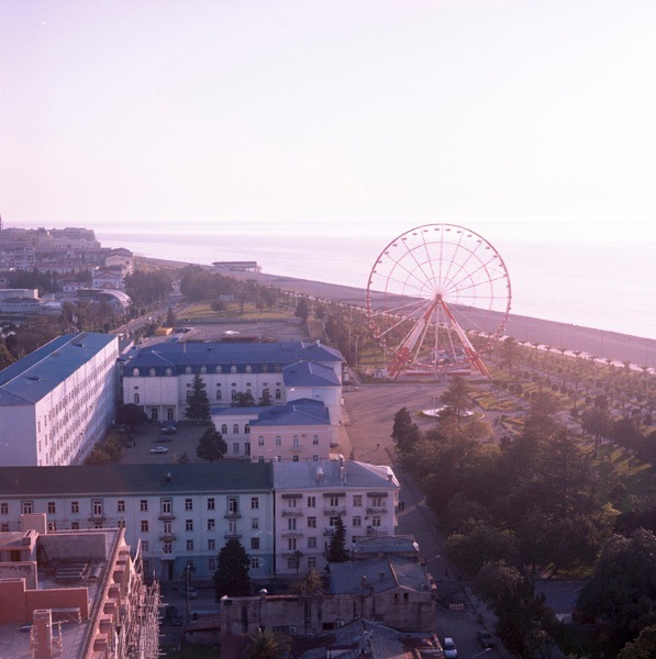 Aerial view of Batumi's Seaside Park with Ferris wheel, Soviet-era buildings and Black Sea coastline.