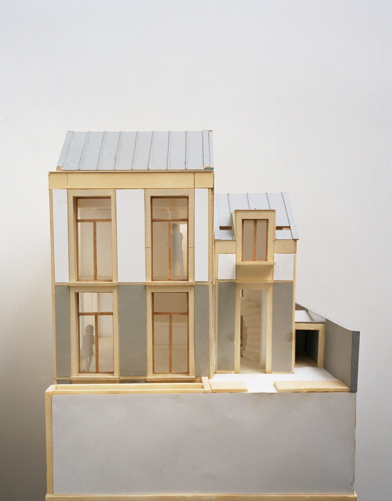 Architectural model of the Rational House showing a multi-level terraced townhouse design with wooden frames and metal roof.