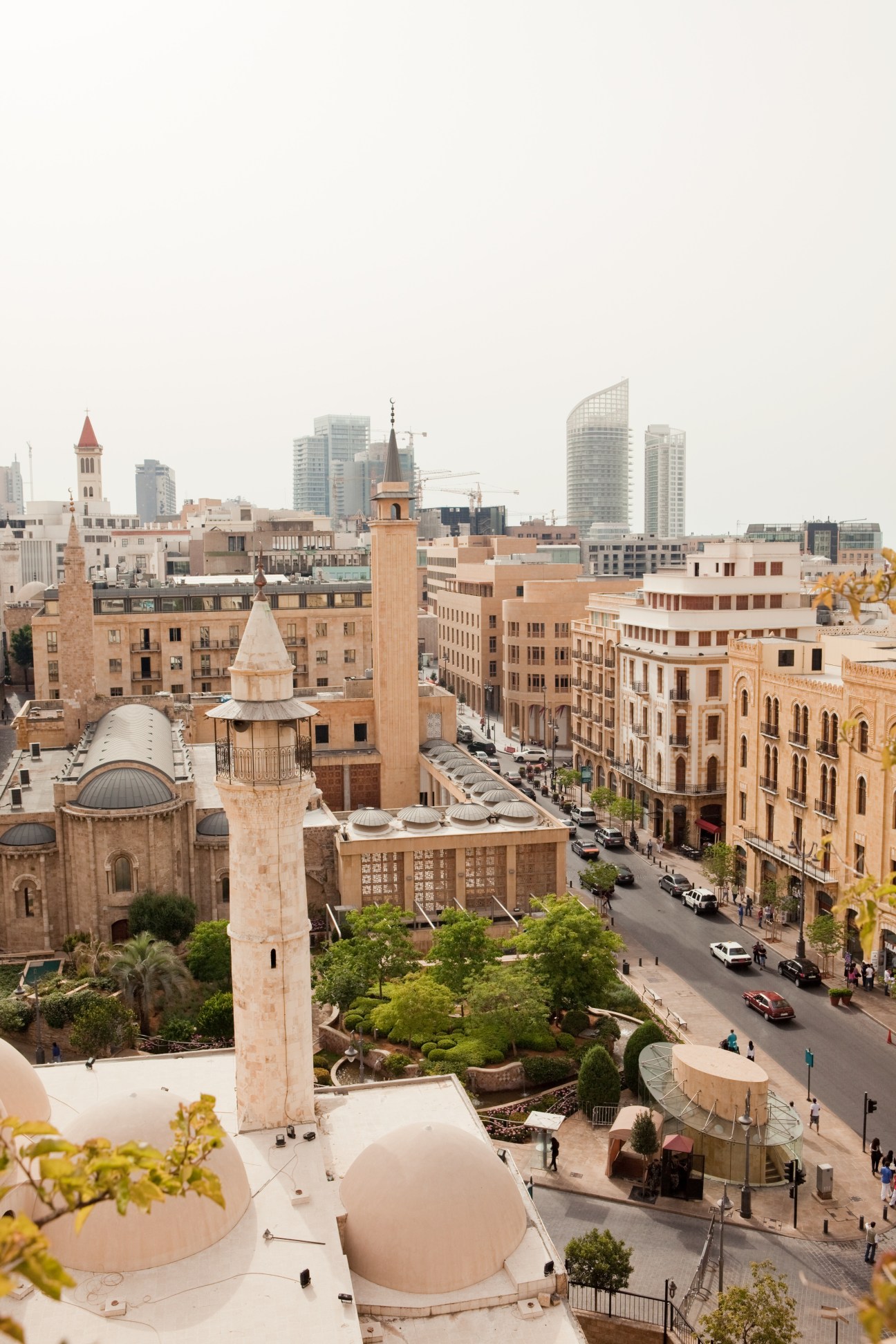 Aerial view of Beirut's downtown cityscape from Le Gray Hotel roof showing historic mosque, modern towers and Mediterranean backdrop.