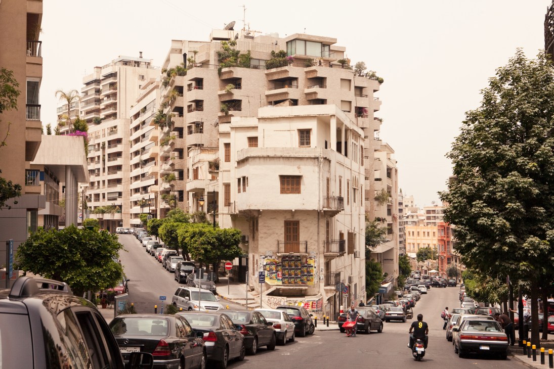Street scene in Ashrafieh showing mixed residential architecture, parked cars, and tree-lined boulevard.