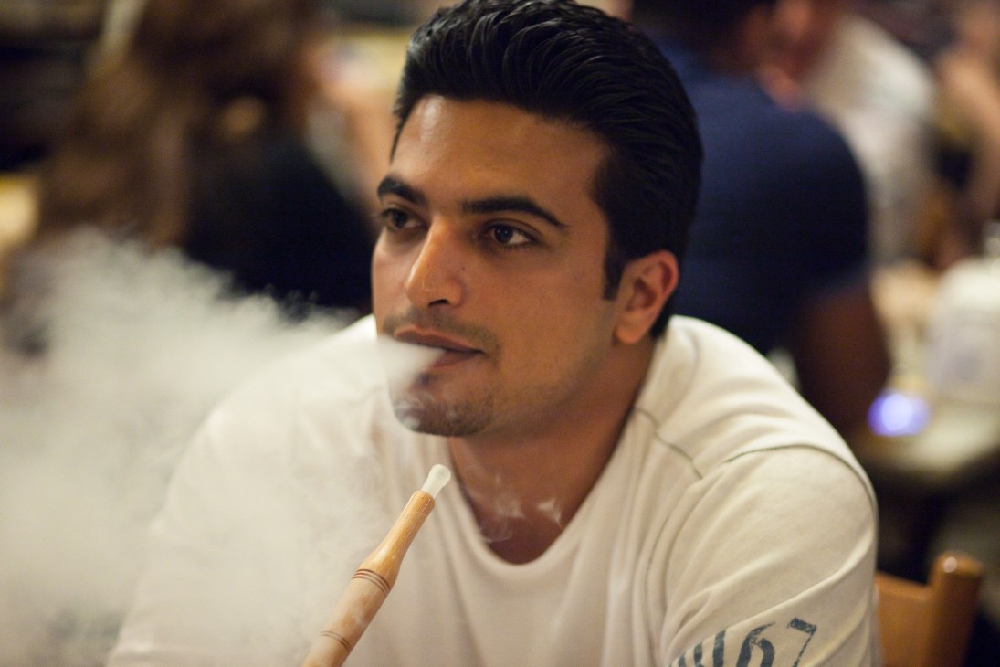 Man smoking a pipe in a café setting in Beirut's Gemmayzeh neighborhood.