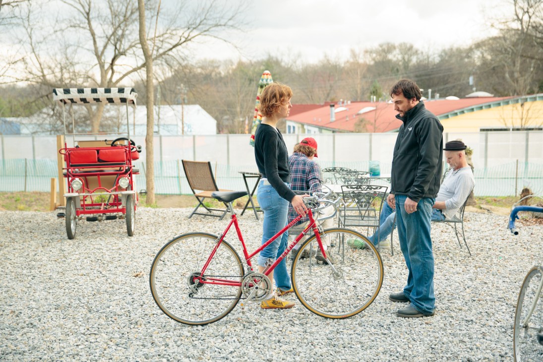 Benjamin Stimis consults with a customer over a red bicycle at Atlanta Beltline Bicycles.