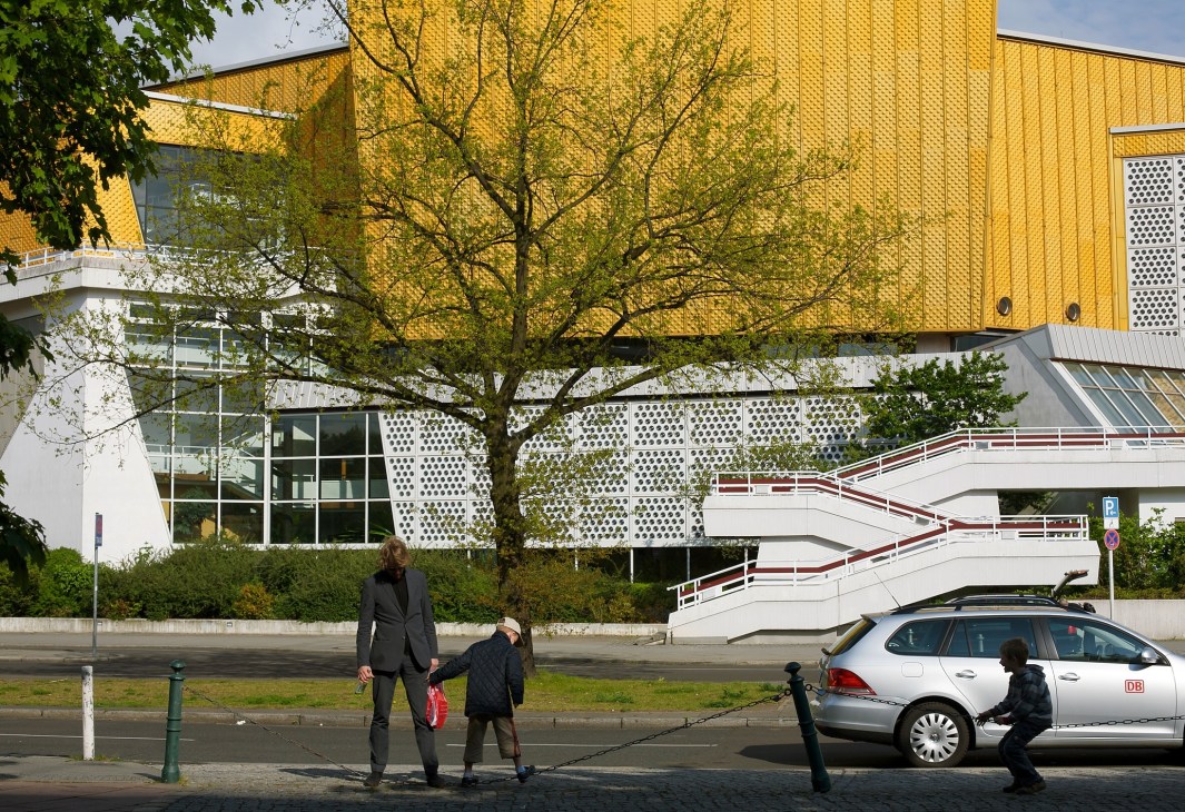 Hans Scharoun's Berlin Philharmonic building with yellow brick upper section and white lower level with perforated panels.
