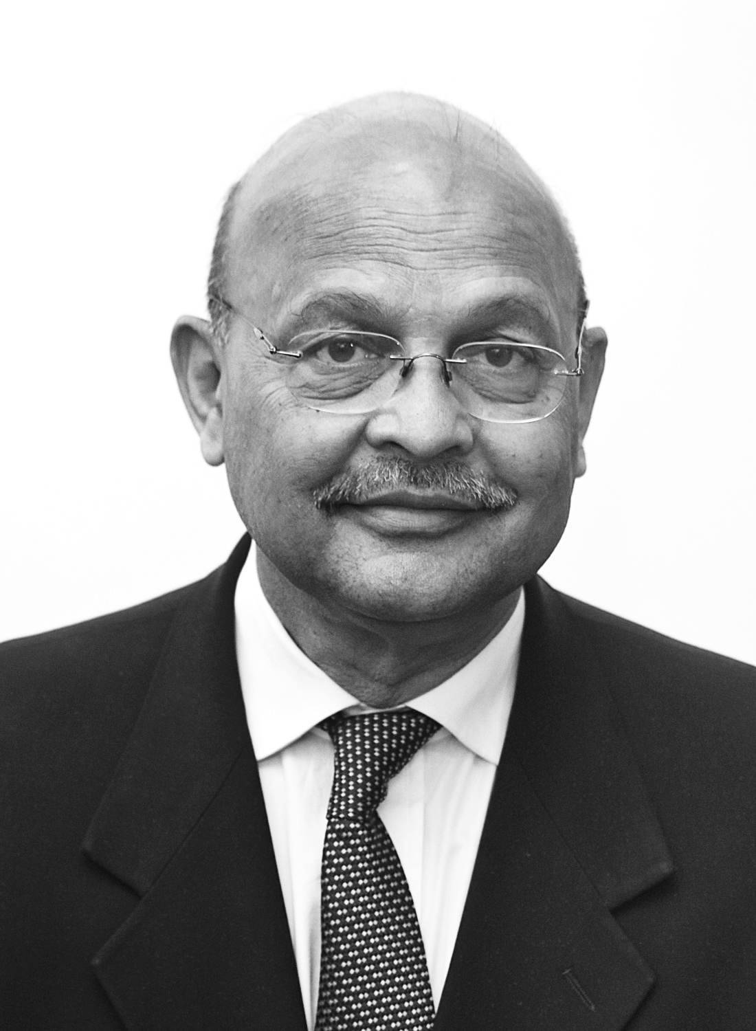 Black and white portrait of Captain Bharat Verma, founder of Indian Defence Review, wearing glasses and a dark suit.