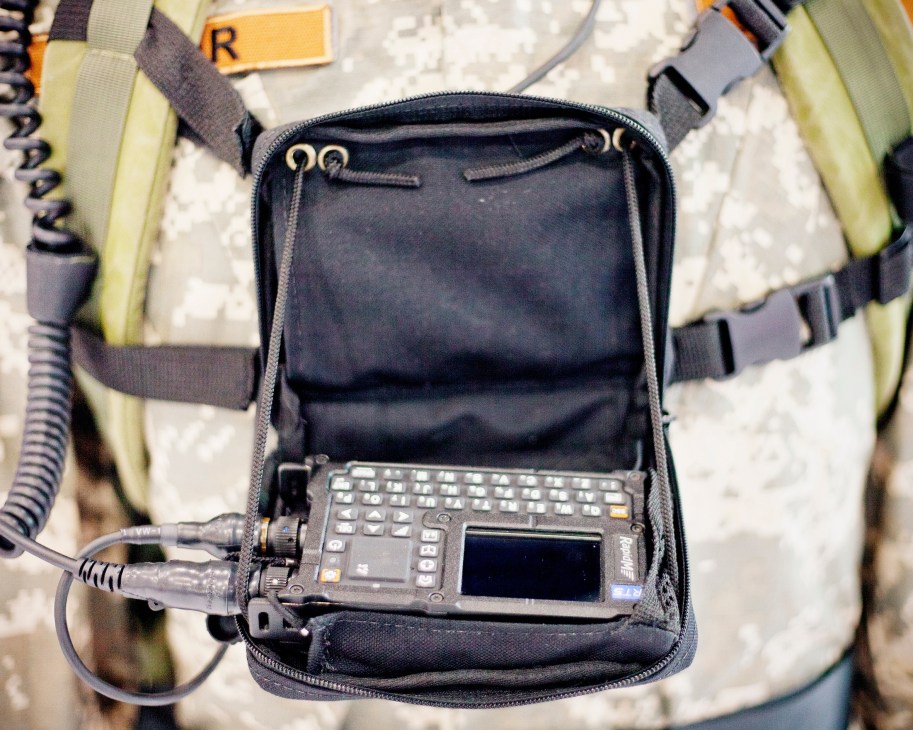 Rapid Mobile RT5 HF radio modem displayed in open carrying case with tactical vest straps visible.