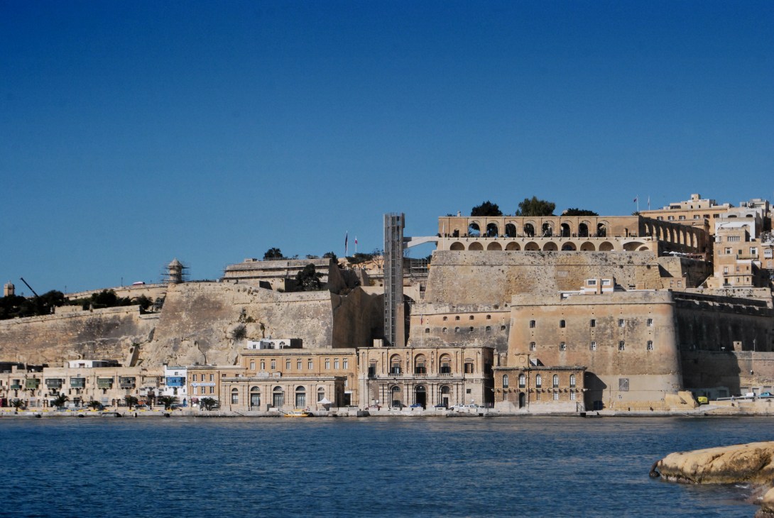 Valletta's waterfront showing historic fortified ramparts and the new modern lift structure connecting upper and lower town.