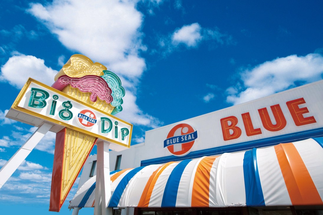 Blue Seal ice cream shop storefront with vintage neon signage and striped awning in Okinawa.