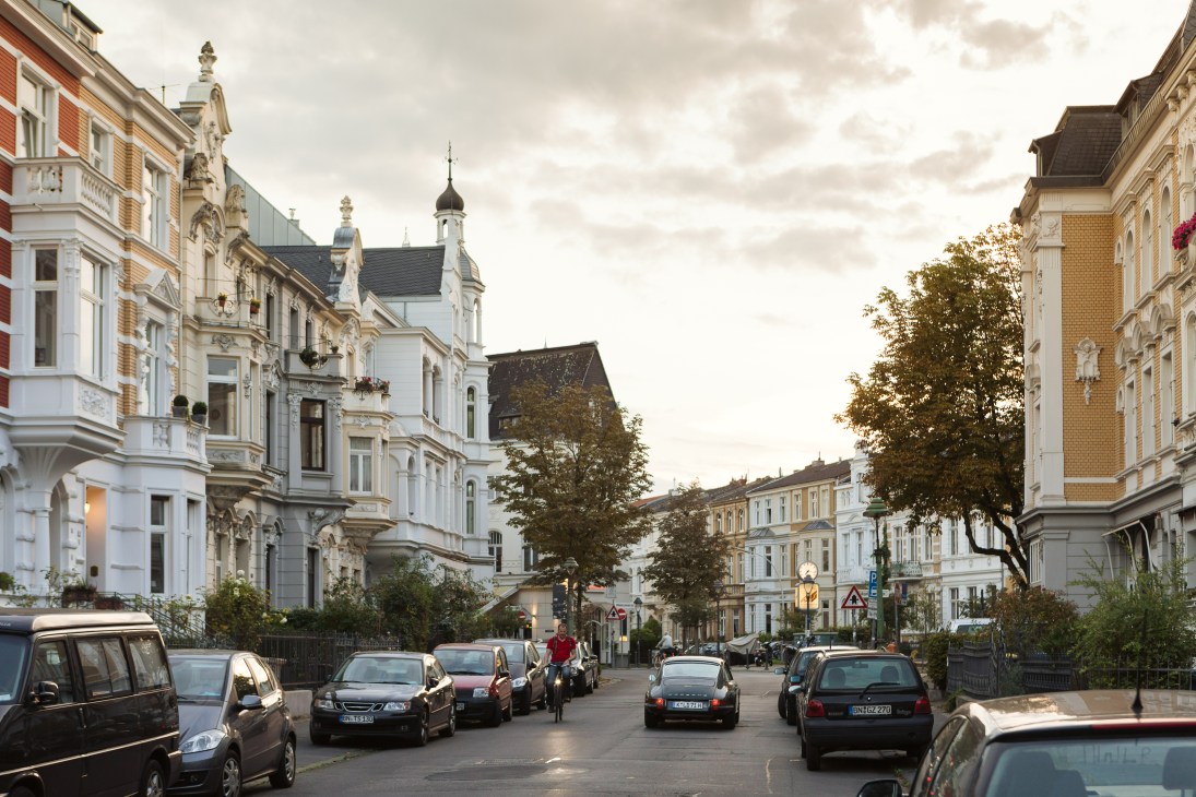 Historic Gründerzeit buildings line a street in Bonn's Südstadt neighbourhood with parked cars.